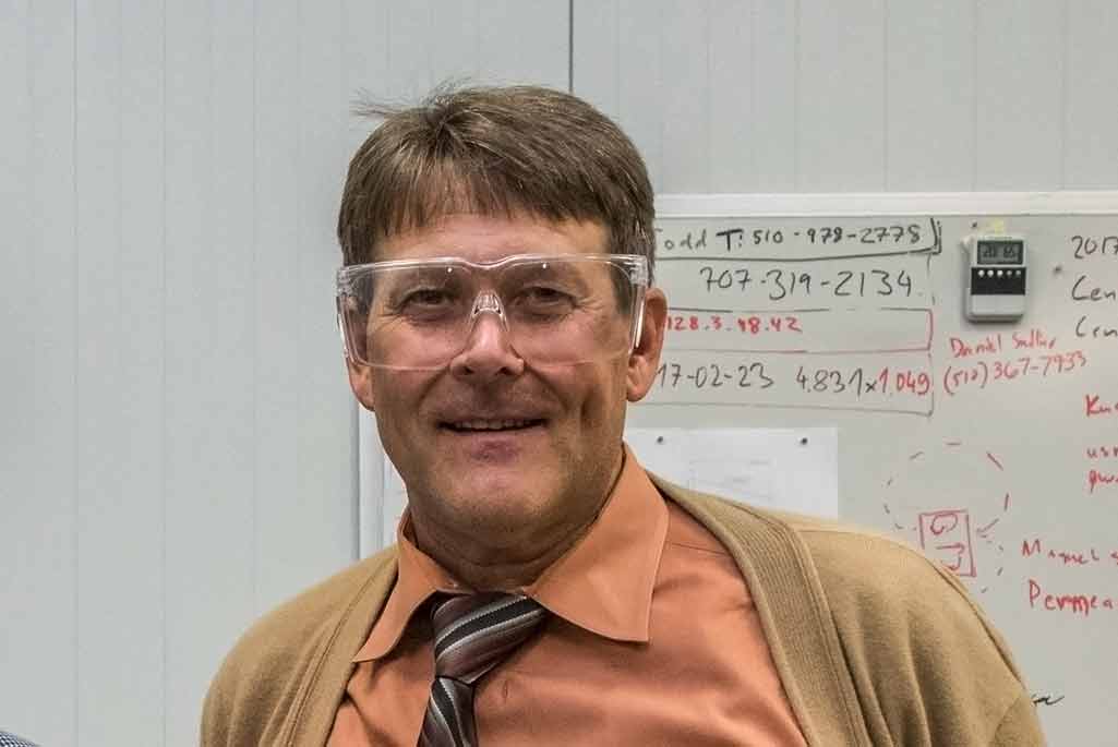 Ross Schlueter in front of a white board