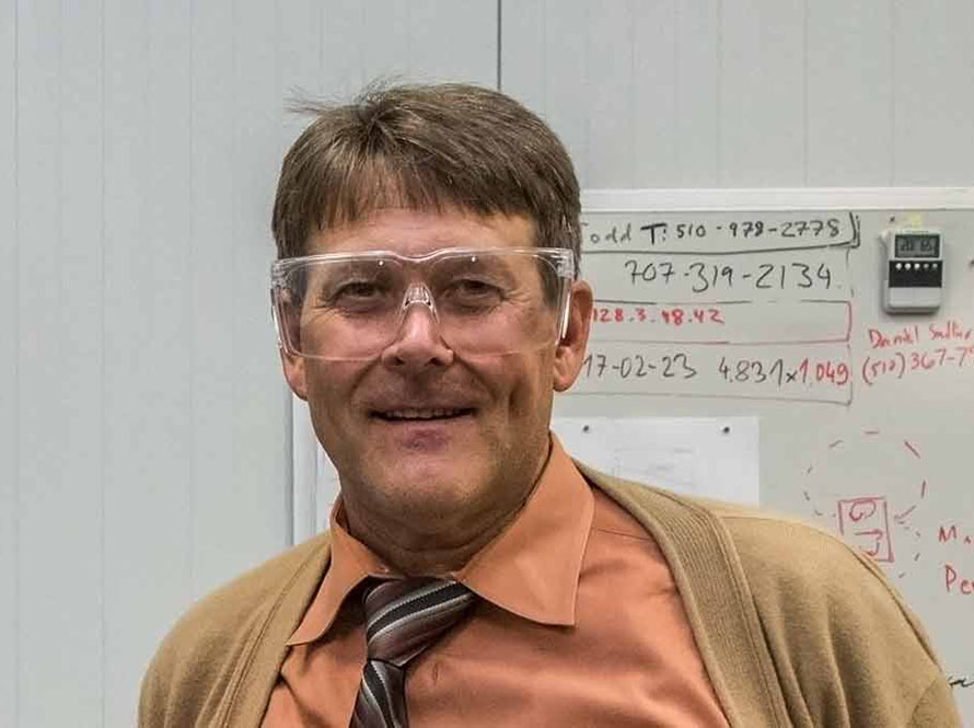 Ross Schlueter in front of a white board