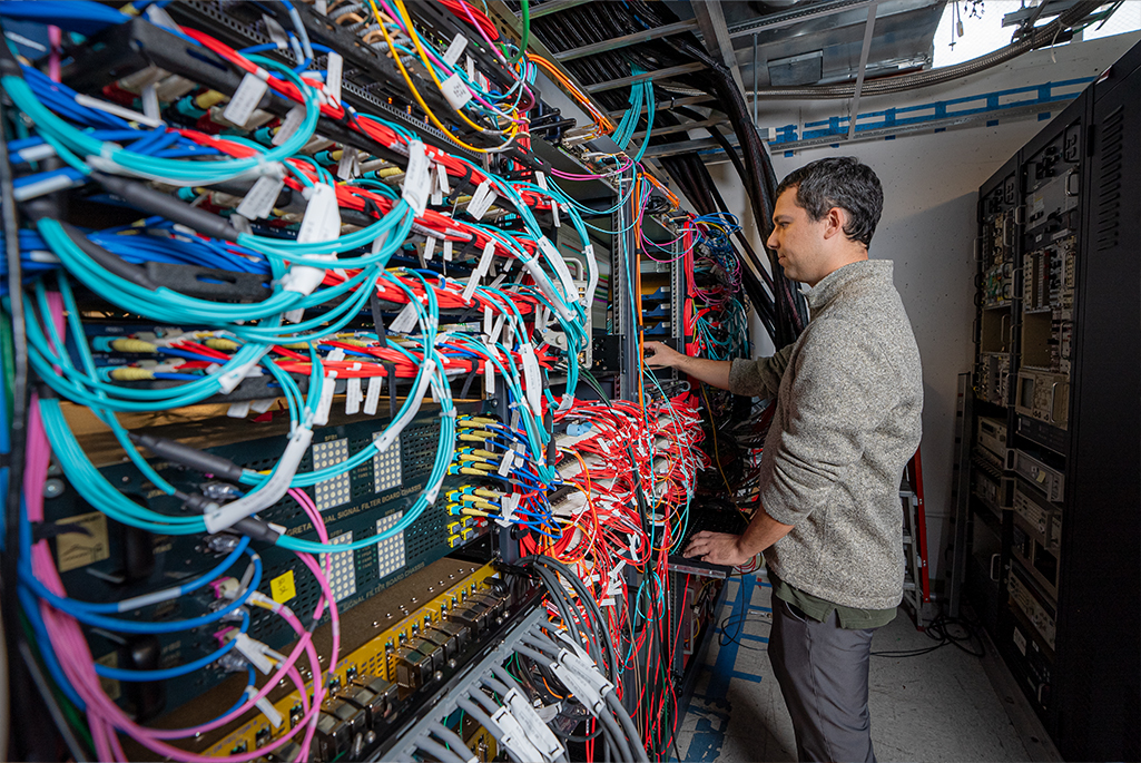 A software developer adjusts GRETA's electronics rack