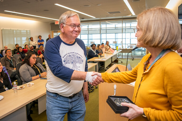 Engineering technologist Ken Lambert receiving his award from Deputy Directory Carol Burns