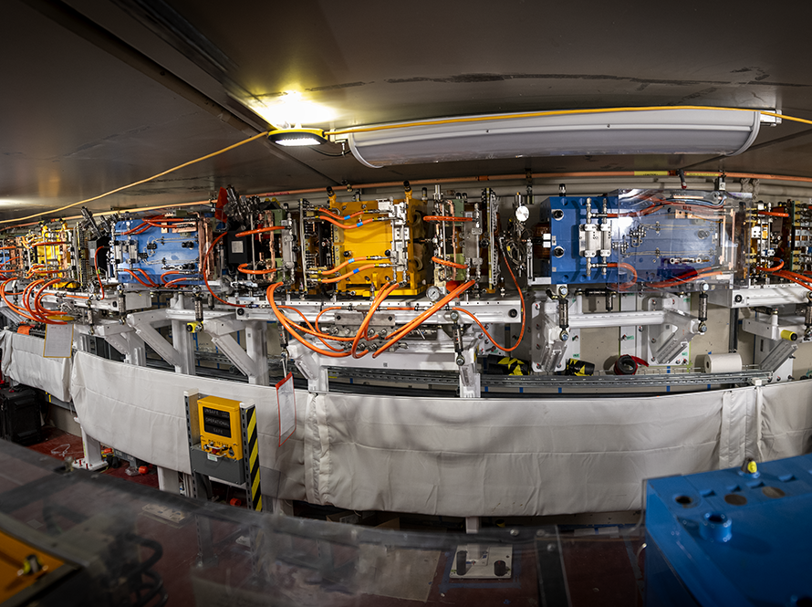 View of complex equipment over many panels with complex wiring and cables.