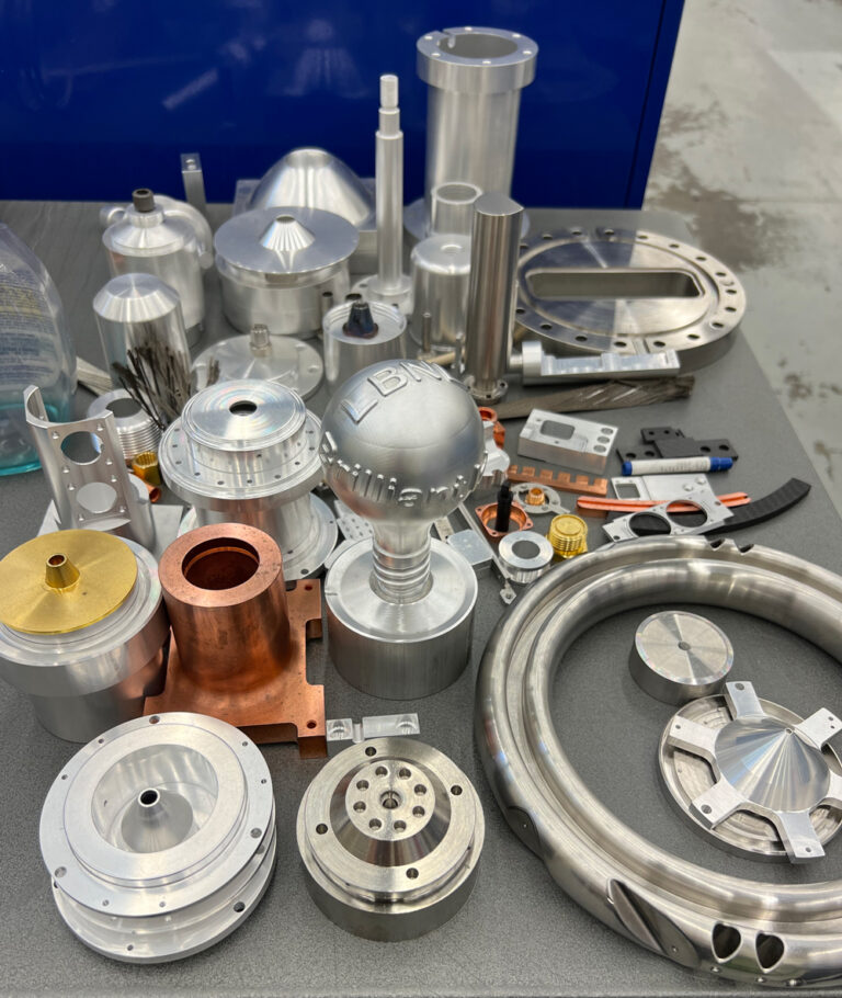 Collection of precision-machined metal components displayed on a work surface