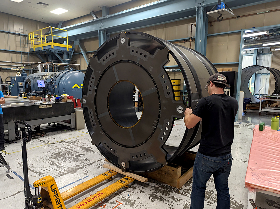 Worker fabricates a large cylindrical section.
