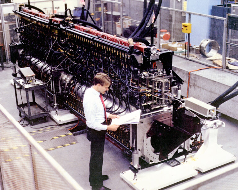 A younger Ross Schlueter in front of the IMP Wiggler at Lawrence Livermore National Laboratory