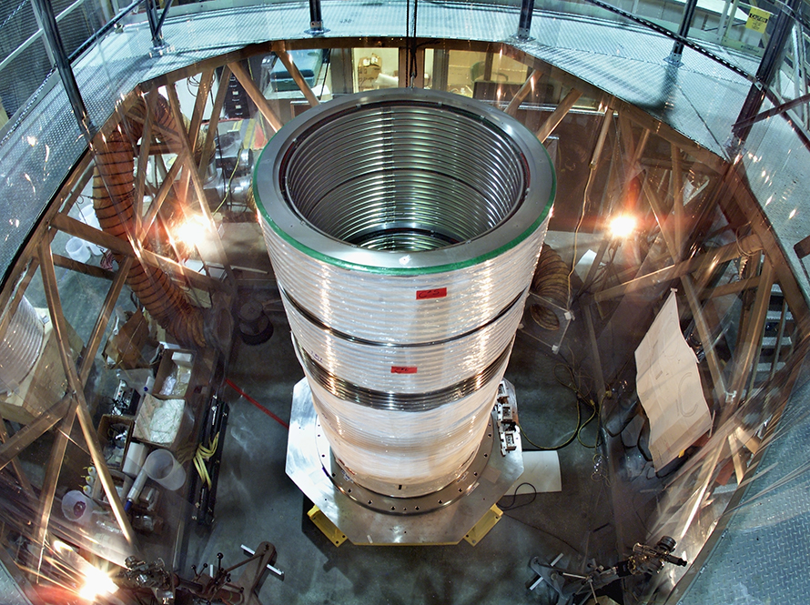 Overhead view of a cylindrical metal component in a workshop.