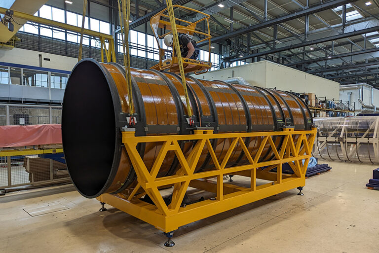 A worker inserting the final pin into the outer cylinder at CERN