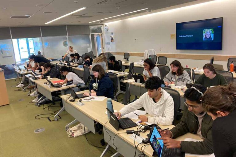 Students in a classroom working on their laptops