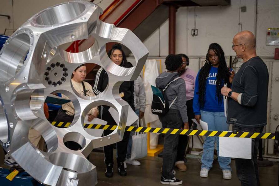 An electronics associate in the engineering Division shows high school students GRETA