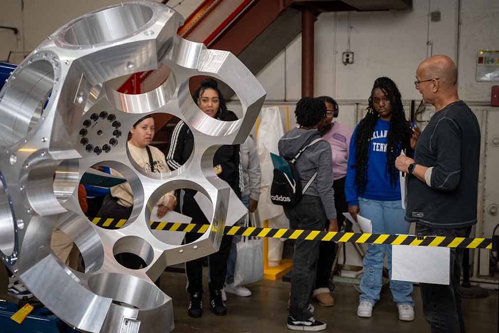 An electronics associate in the engineering Division shows high school students GRETA