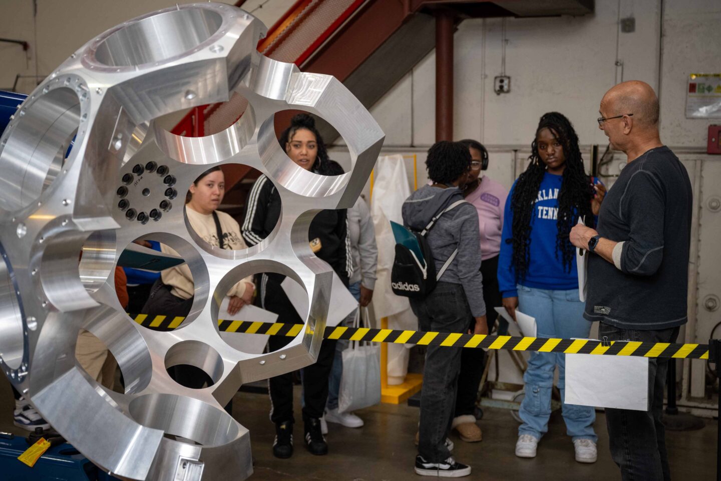 An electronics associate in the engineering Division shows high school students GRETA