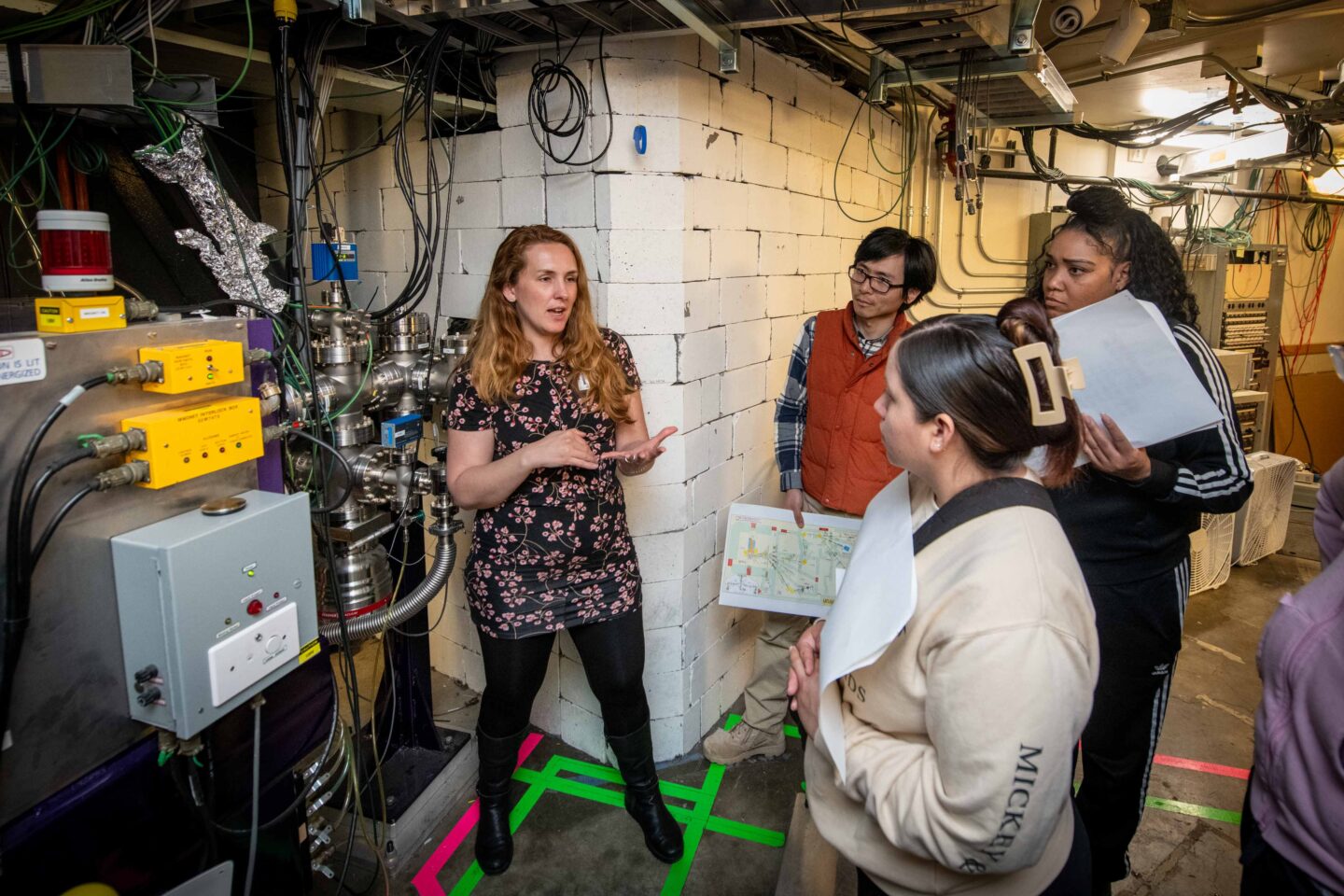 A researcher talks to students at the 88-Inch Cyclotron