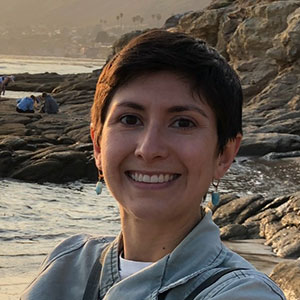 Headshot of Jessica Aguilar with a rocky shoreline in the background