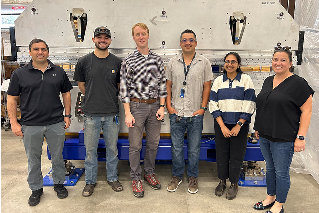 Engineering division team members pose in front of LCLS-II x-ray laser