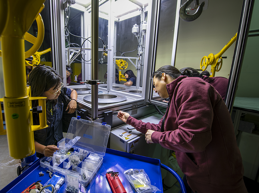 Researchers adjust apparatus in a lab.