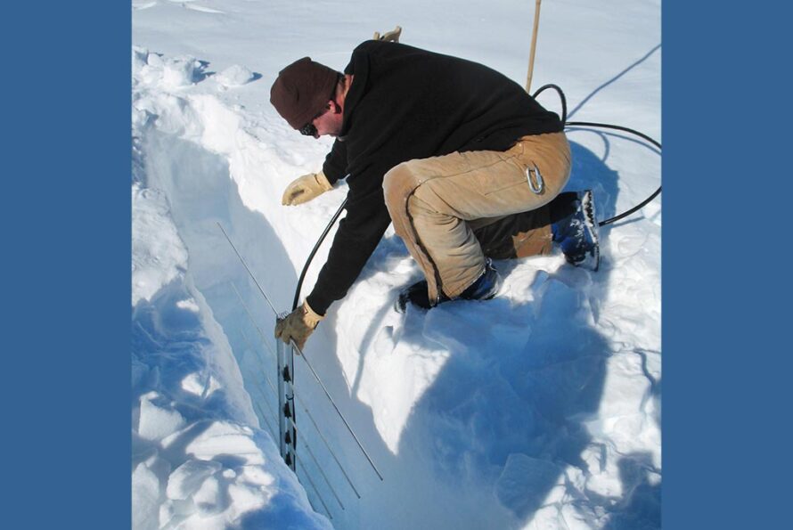 Berkeley Lab Electronics Engineer Thorsten Stezelberger places an antenna in a hole in the Ross Ice Shelf in Antarctica.
