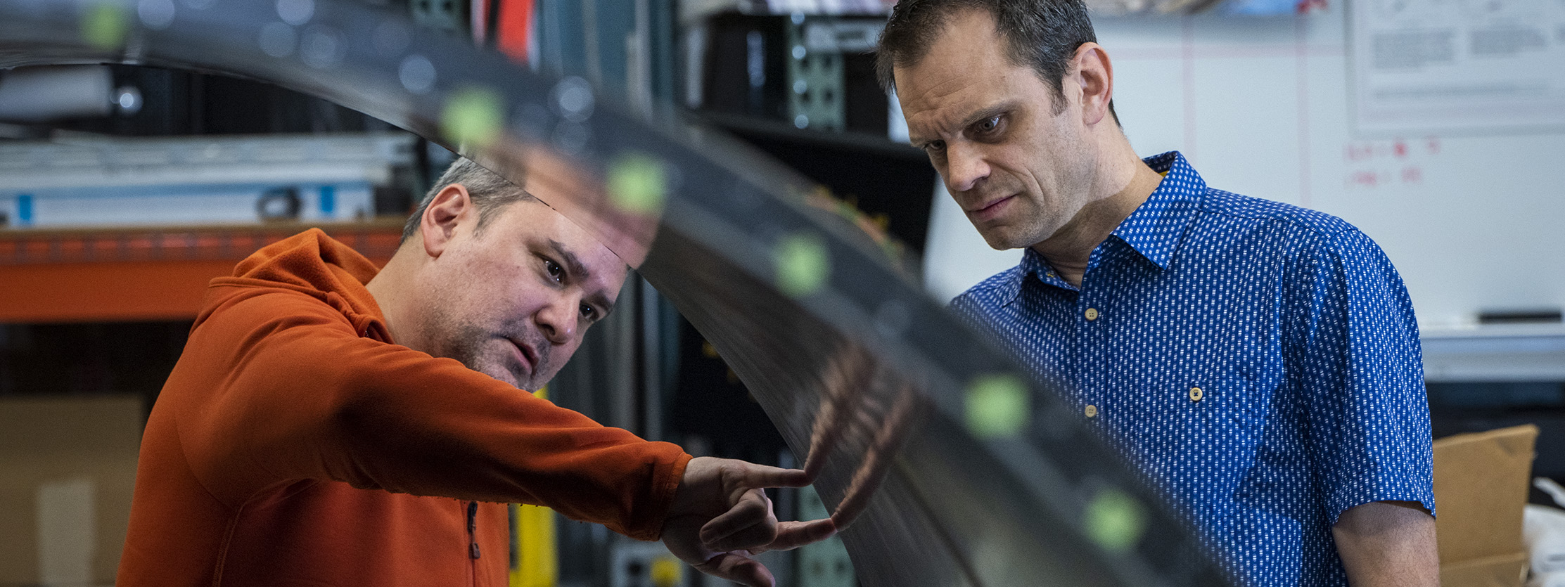 Two people looking at the edge of an L2 Barrel.