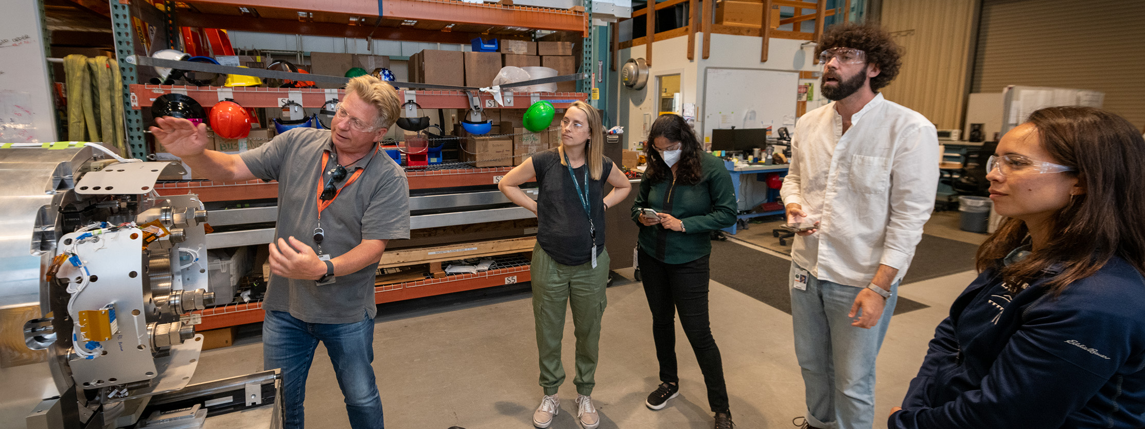 Senior scientist talking with early career program participants in engineering workshop.