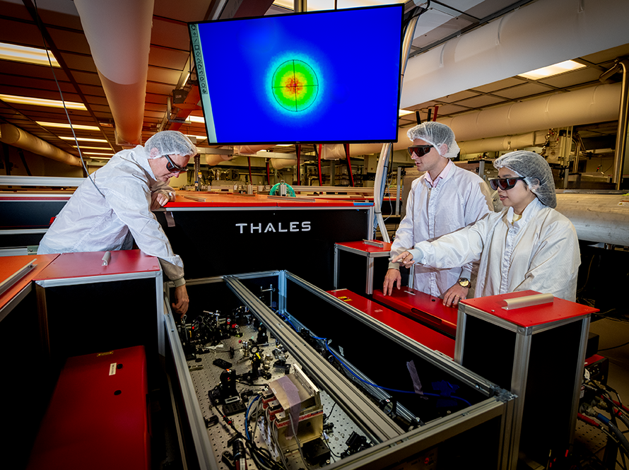 Researchers in PPE work on equipment.