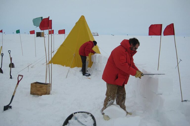 Two researchers cuts ice blocks during safety training at McMurdo Station