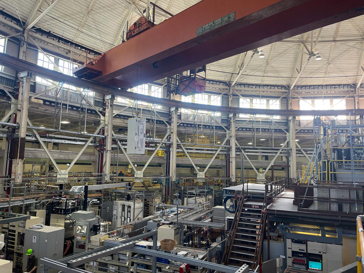 Electronics rack suspended from overhead crane in ALS with visible beam structure and scientific equipment below