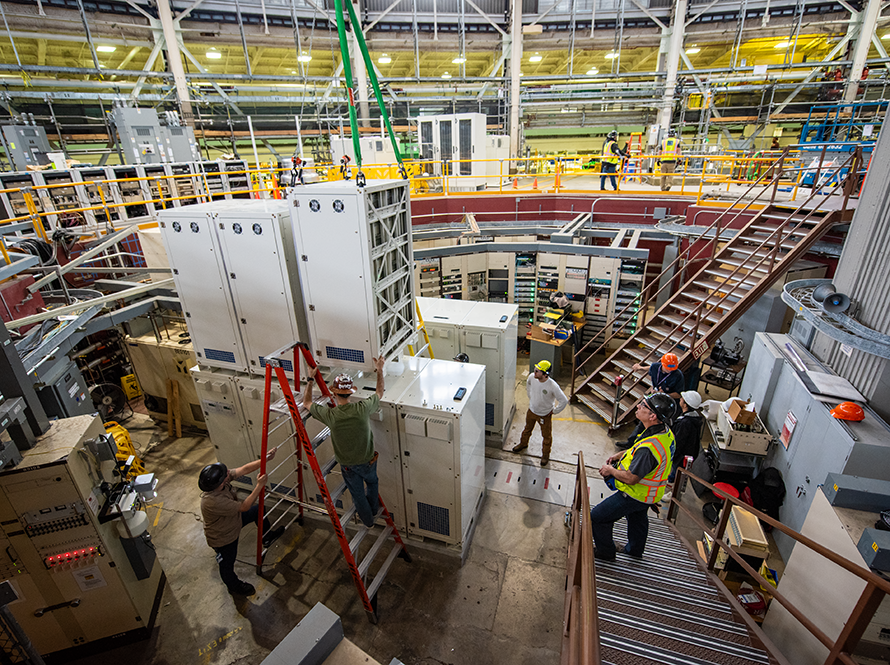 Workers in hard hat and vests unloading equipment in ALS.