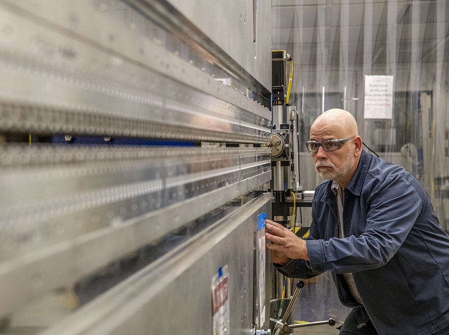 Technician adjusting equipment on an accelerator beamline.