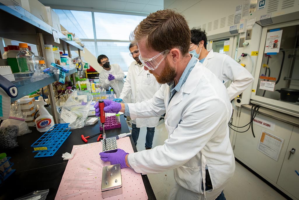 Mechanical Engineer Nick Wenner, a member of the Engineering Small Project Support (EsPS) team, demonstrates the method for sealing each well in the small high-throughput pressure reactor he designed and built for use in specialized experiments.