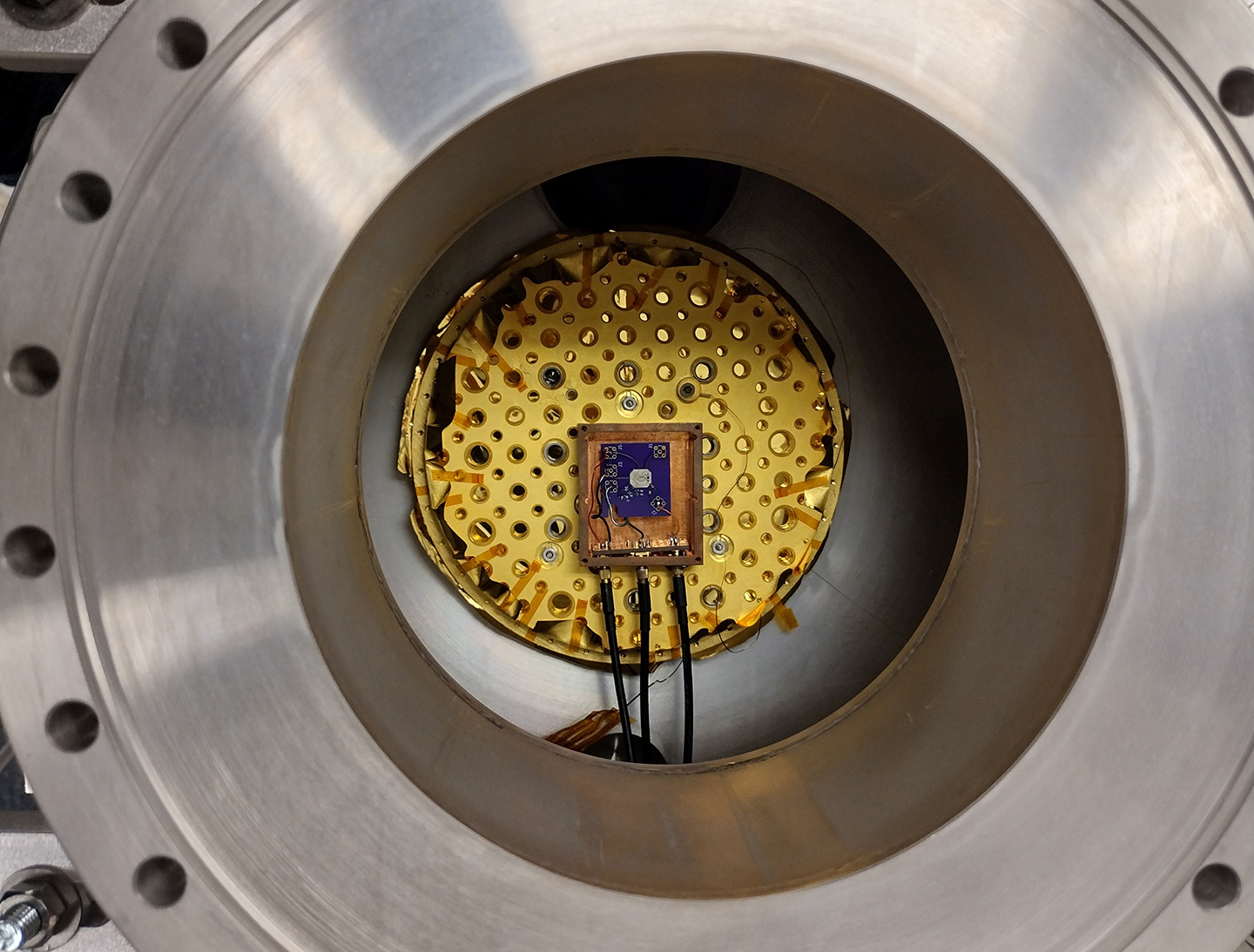 A chip testing setup positioned at the center of a metal sphere.