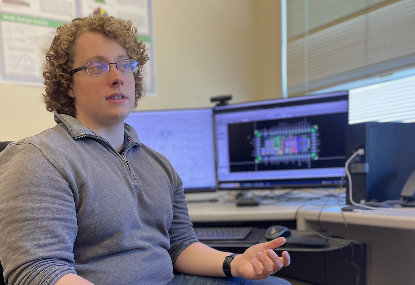 Engineer Will Wright explains an ASIC’s design in front of a computer showing the chip schematic.