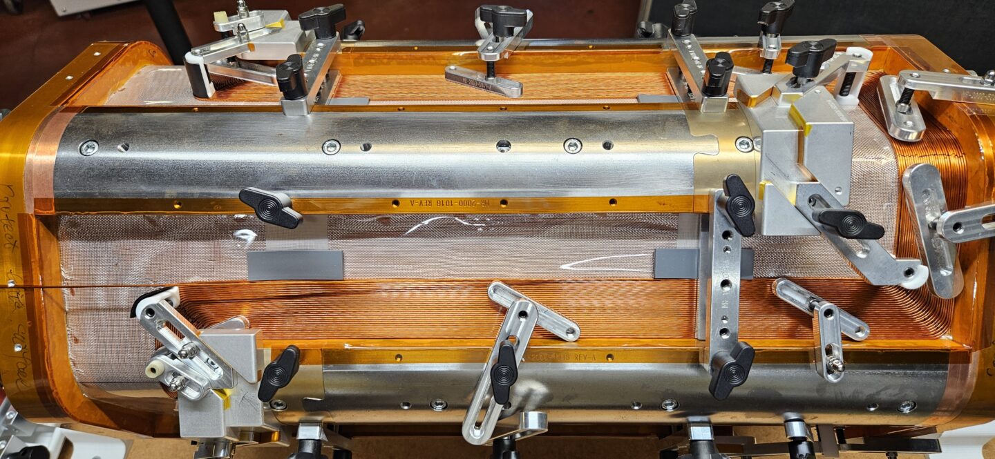 Clamps positioned on the CLC for the MARS-D magnet mandrel hold the Nb-Ti superconducting wire in place.