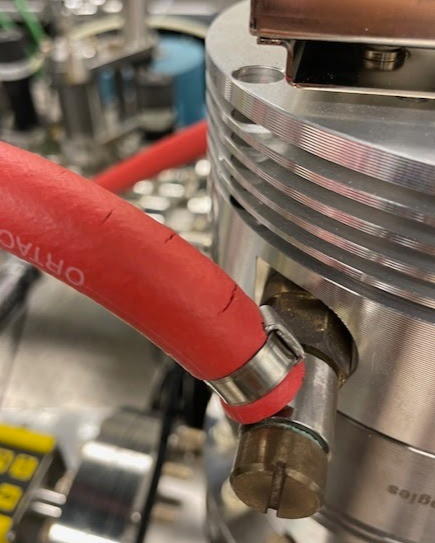 A red water hose, showing signs of cracking.