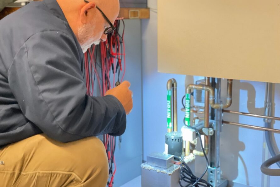 Tom Lipton uses a flashlight to inspect water pipes and their connections.