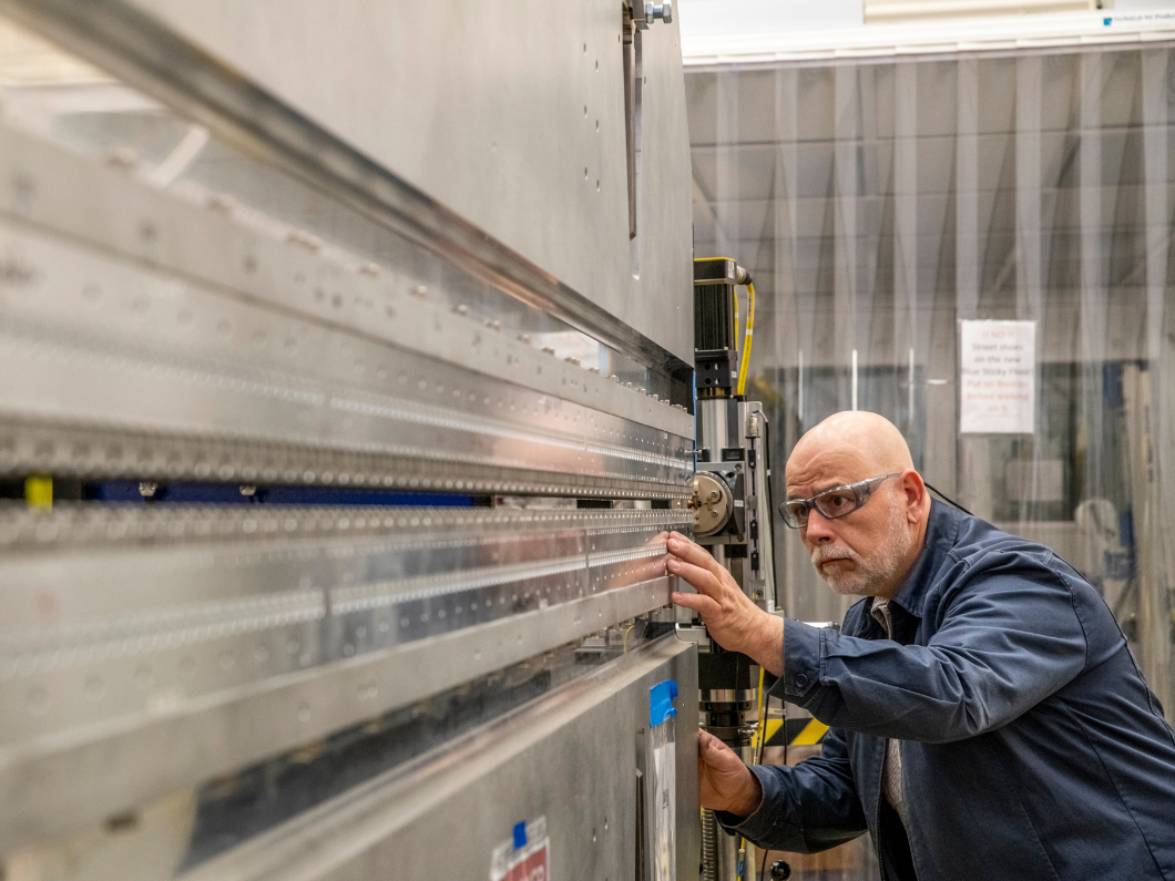 Tom Lipton fine tuning the mechanics of a Berkeley Lab-designed and built soft X-ray undulator for the Linac Coherent Light Source (LCLS-II) at SLAC.