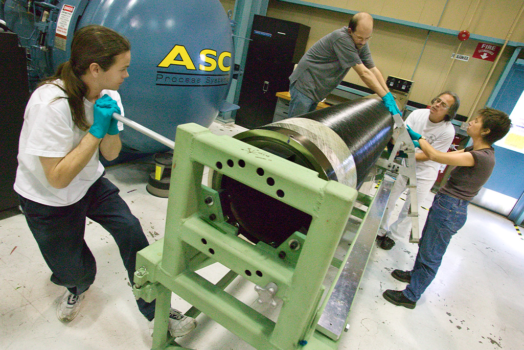 Thomas Johnson (left) and other members of Berkeley Lab's ATLAS project engineering team assemble the carbon fiber support tube for the ATLAS Pixel Detector (April 2004).