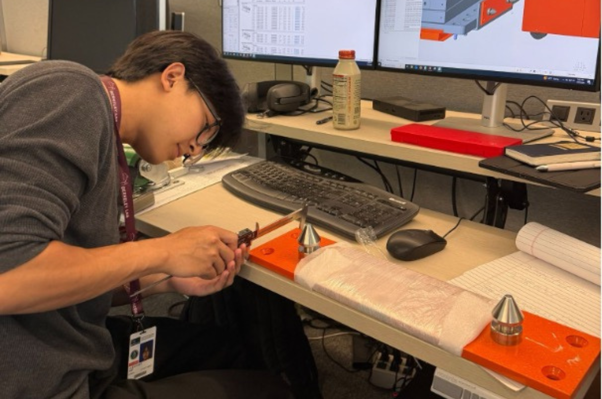 Alex Kim taking measurements to design and model a new adapter plate for ALS-U.