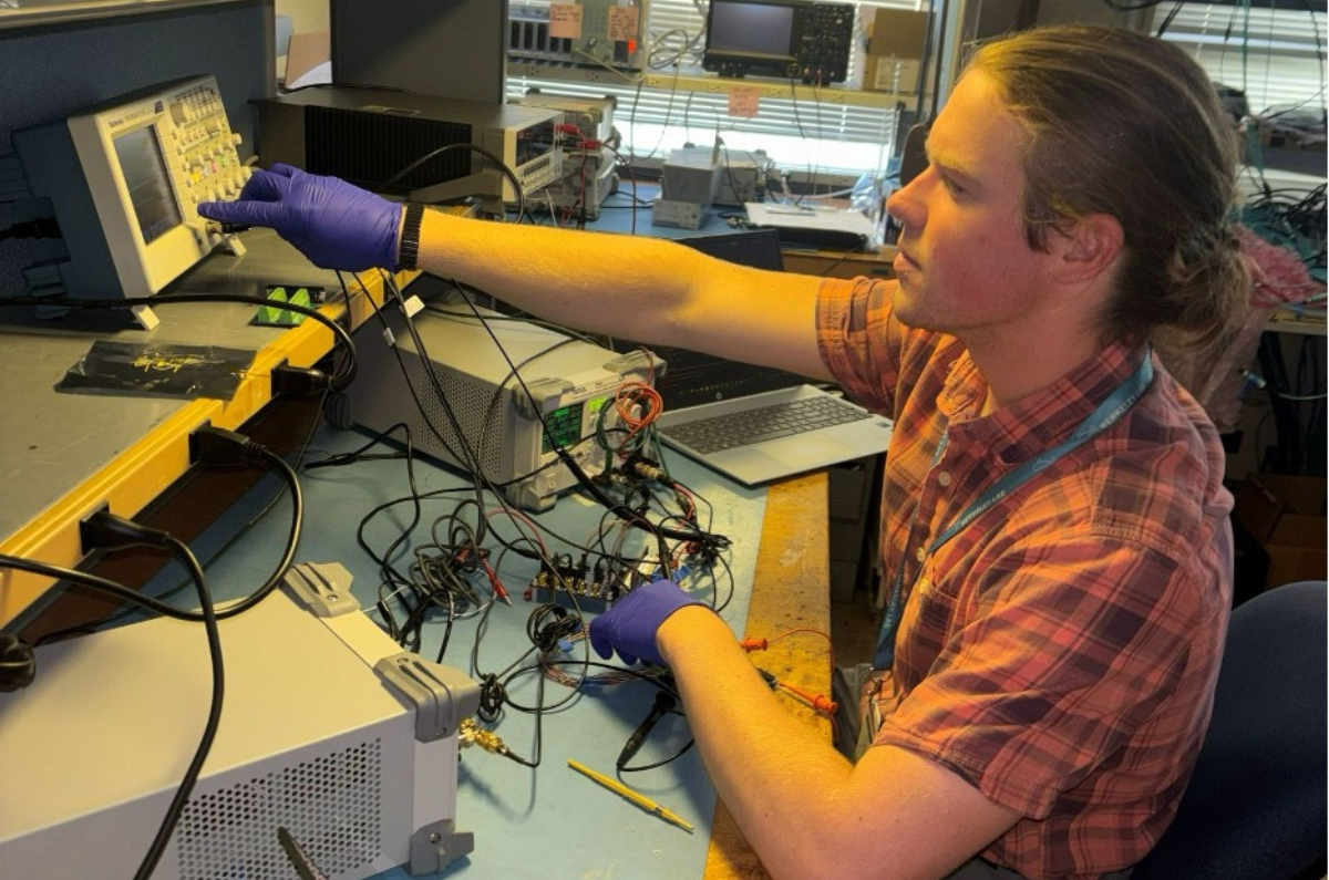 William Henry debugging electrical signals on his chip board.